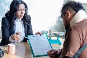 Young,Lawyer,Showing,A,Document,Paper,To,A,Male,Client.,
